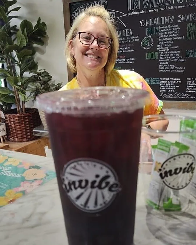 A smiling person behind InVibe cups at the club counter in April 2023