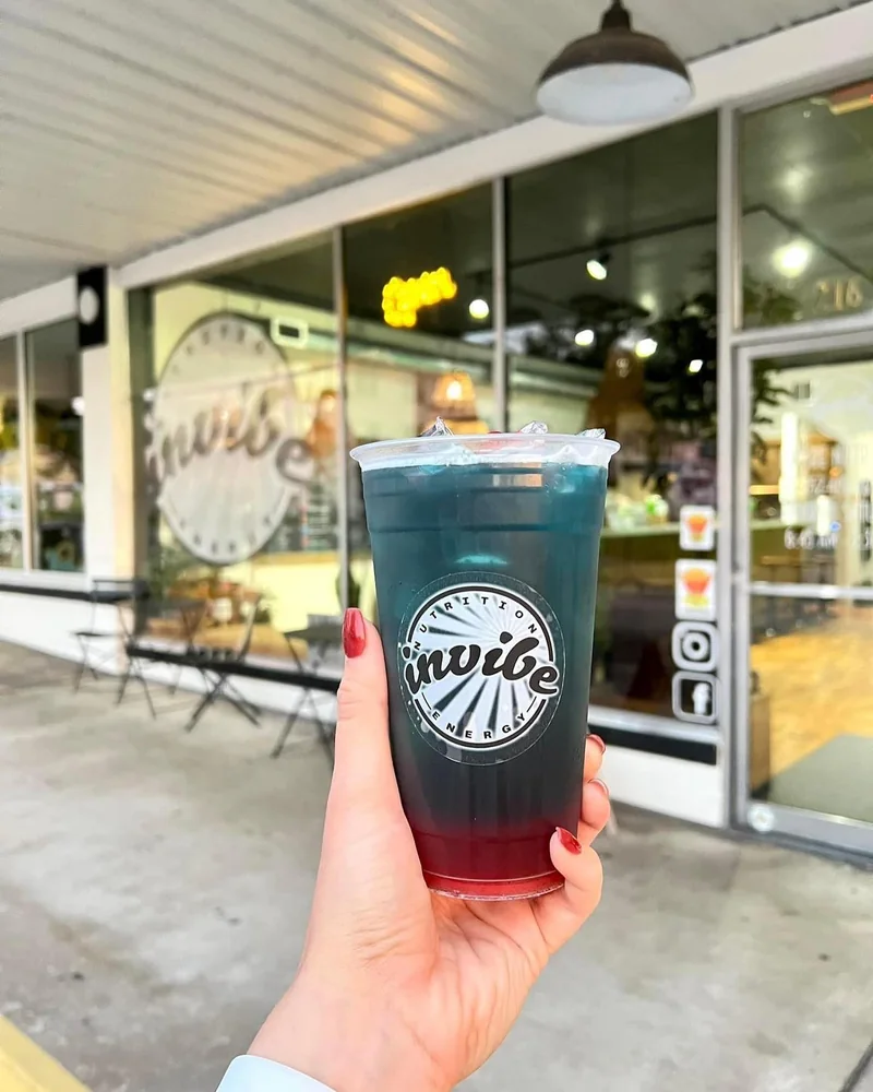 A hand holding an InVibe tea outside the signed club windows in August 2023