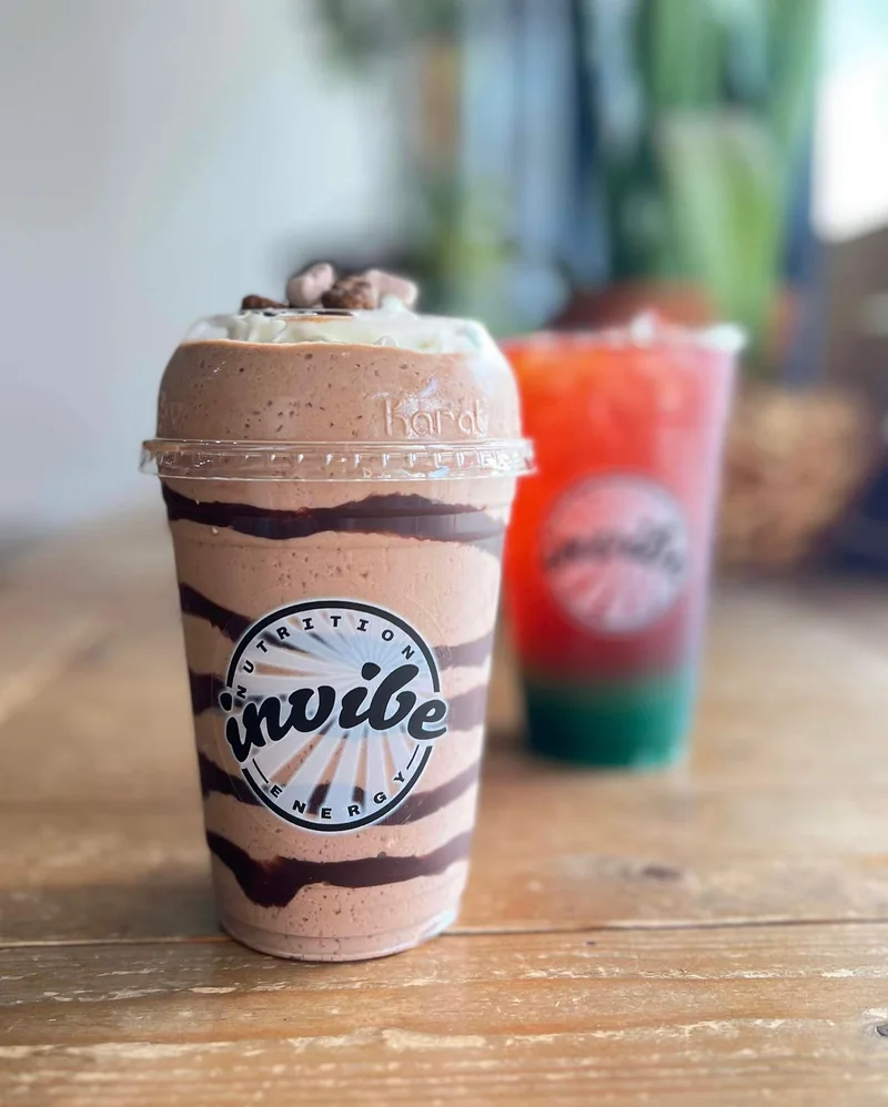 A chocolate InVibe shake with a whipped topping on the wooden counter