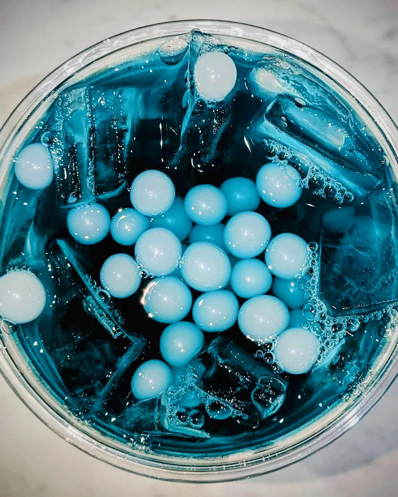 An overhead photograph of a blue InVibe tea with pale boba